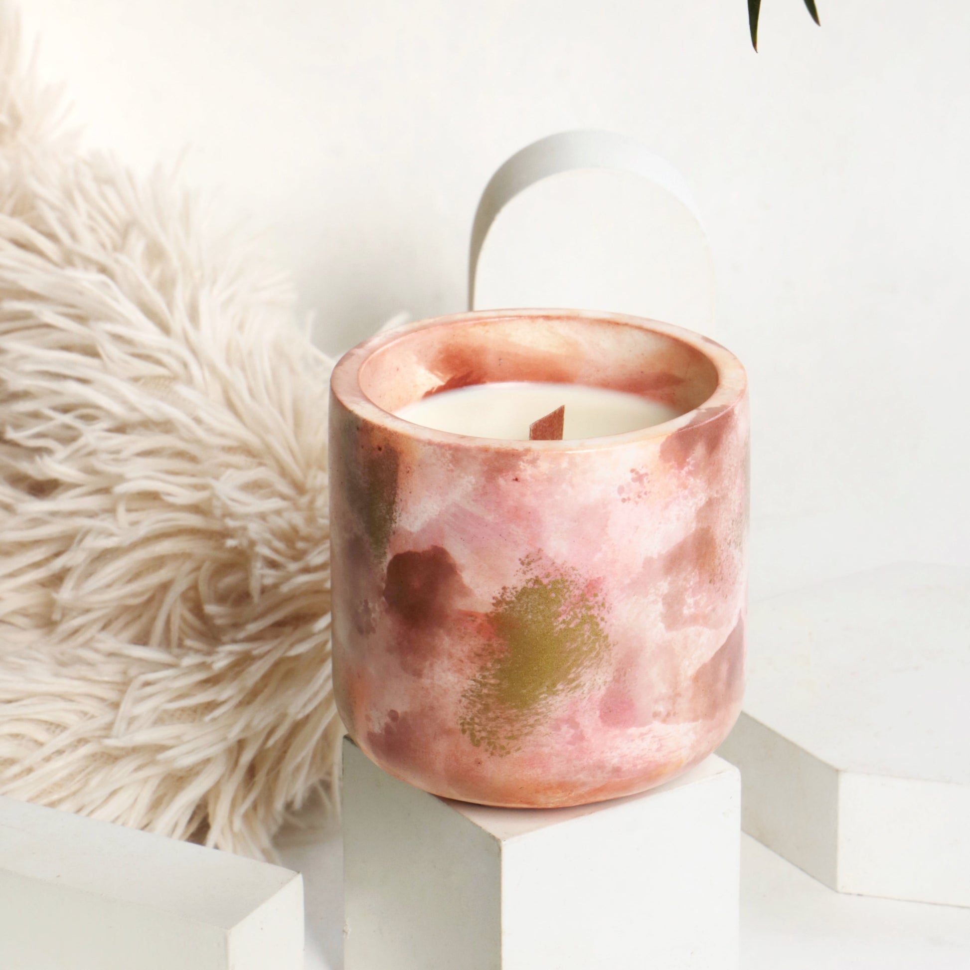 Scented candle burning brightly, casting a soft glow